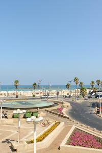 a view of a beach with palm trees and the ocean at Liber Tel Aviv Sea Shore Suites BY RAPHAEL HOTELS in Tel Aviv