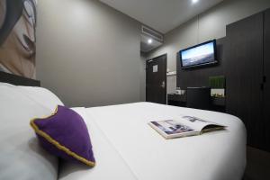 a bedroom with a bed with a pillow and a tv at V Hotel Lavender in Singapore