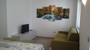 - un salon avec un canapé et une télévision dans l'établissement Chalet La Perla Molveno, à Molveno