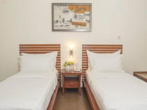 ジャカルタにあるd'primahotel Melawai - Blok Mの部屋に並んで置かれた2つのベッド