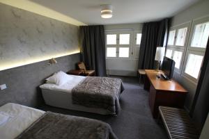 una camera d'albergo con 2 letti e una scrivania di Hotel RokuanHovi a Rokua