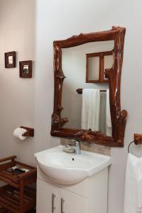 a bathroom with a sink and a mirror at Knysna Elephant Park Lodge in Plettenberg Bay
