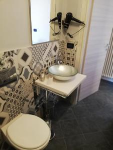 een badkamer met een wastafel, een toilet en een spiegel bij B&B IL SOGNO in Turijn