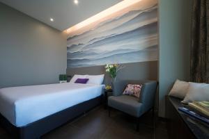 a hotel room with a bed and a chair at V Hotel Lavender in Singapore