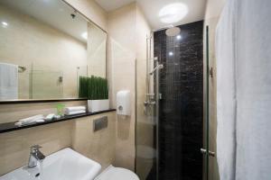 a bathroom with a shower and a toilet and a sink at V Hotel Lavender in Singapore