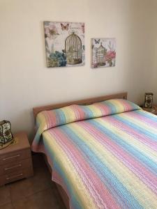 ボルガニェにあるCasette nel Borgoのベッドルーム1室(カラフルな毛布と鳥の檻付きのベッド1台付)