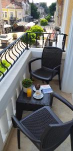 a balcony with two chairs and a table with a drink at Hotel Central in Ruse