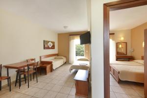 a hotel room with a bed and a dining room at Amalia in Paleo Tsifliki