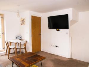 a living room with a table and a tv on the wall at Impressive Urban Townhouse - Leeds City Centre in Leeds