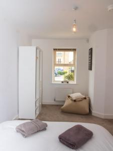 a white bedroom with a bed and a window at Impressive Urban Townhouse - Leeds City Centre in Leeds