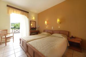 a bedroom with a bed and a chair and a window at Amalia in Paleo Tsifliki