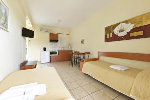 a room with two beds and a kitchen at Amalia in Paleo Tsifliki