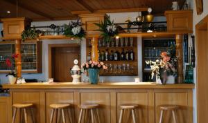 a bar with stools and bottles of wine at Pension Rupertstubn in Ingolstadt