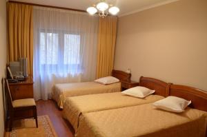 A bed or beds in a room at Pensiunea Magura