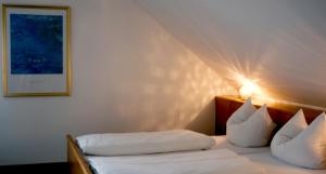 a bedroom with a bed with white sheets and pillows at Pension Rupertstubn in Ingolstadt