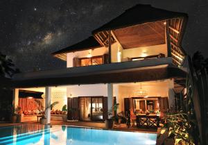 uma villa com piscina à noite em Joya' Beach Suites & Villa em Jambiani