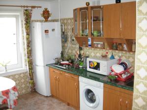 a kitchen with a refrigerator and a washing machine at Happy Land in Jūrmala