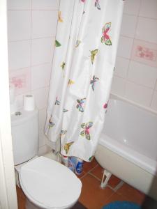 a bathroom with a toilet and a shower curtain with butterflies at Happy Land in Jūrmala