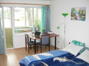 a bedroom with a bed and a desk with a laptop at Happy Land in Jūrmala