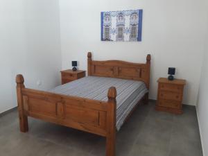 a bedroom with a wooden bed and two night stands at Quinta Cosy in Paderne