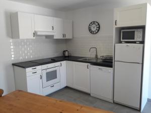 a kitchen with white cabinets and a white refrigerator at Quinta Cosy in Paderne