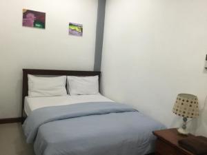 een slaapkamer met een bed met witte lakens en een lamp bij Jamie's home with 2 bedrooms, can accommodate 6 guests in Ko Samed