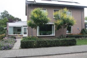 a brick house with trees and flowers in front of it at tisOKE in Vught