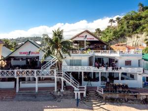 a white building with a restaurant on the beach at Scandi Divers in Puerto Galera