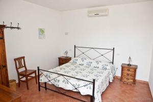 a bedroom with a bed and a chair at La Nostra Maremma in Marsiliana