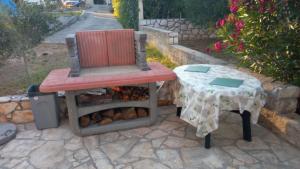 a chair sitting next to a table with at Apartments Aleksandra in Rab