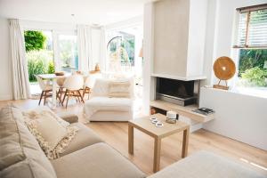 a living room with a couch and a fireplace at Luxury villa on peaceful location. Boat optional in Vinkeveen