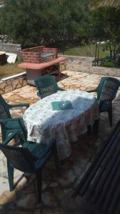 a table and chairs with a table and a bench at Apartments Aleksandra in Rab