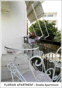 a glass table and chairs on a balcony at Florian Flat Complex in Preveza