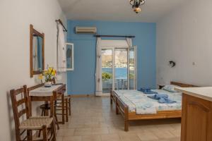 Habitación azul con cama y mesa en Olga Apartments en Alinda