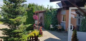 un jardín con un árbol y una casa en Sebar en Gorzyce