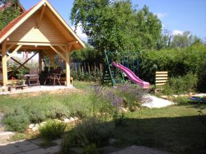 a backyard with a playground with a slide and a gazebo at Levendulas Apartman in Balatonalmádi