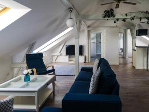 a living room with blue couches and a table at Gutshof Groß Behnkenhagen in Groß Behnkenhagen