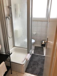 a small bathroom with a shower and a toilet at Appartement Leon in Düsseldorf
