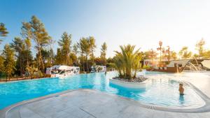 a large swimming pool with people in the water at Mobile Homes Camping Santa Marina, Lanterna in Poreč