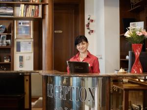 une femme assise dans un bar avec un ordinateur portable dans l'établissement Hotel Sirius, à Karlovy Vary