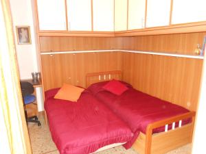 un letto con lenzuola rosse in una stanza con finestra di Appartamento Elisabetta a Lido di Venezia