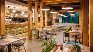 a restaurant with tables and chairs and a bar at Mobile Homes Camping Santa Marina, Lanterna in Poreč