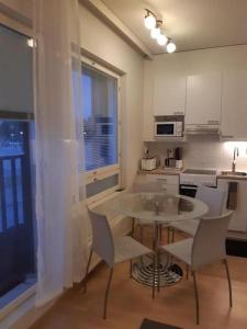 a kitchen with a table and chairs in a room at Pieni moderni saunallinen kaksio keskustan lähellä in Pori