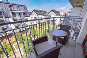 a balcony with a table and chairs on a balcony at Apartamenty na Wyspie - Aquamarina - Budynek A - B - C in Świnoujście