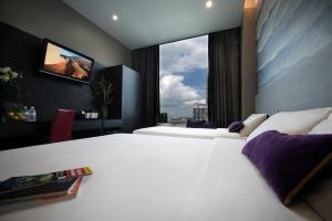 a hotel room with two beds and a window at V Hotel Lavender in Singapore