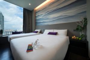 two beds in a hotel room with a large window at V Hotel Lavender in Singapore
