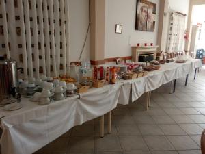 a long row of tables with dishes and cups on them at Vias in Neapolis