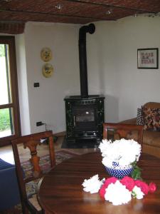a wood stove in a living room with a table at La Miseria in Ovada
