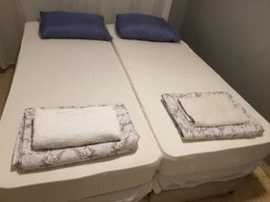 two beds with white sheets and blue pillows on them at רויאל פארק1 in Eilat +8 photos