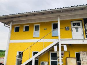 マルヒトレンクにあるApartment´s Marchtrenkの白いドアと窓のある黄色い建物